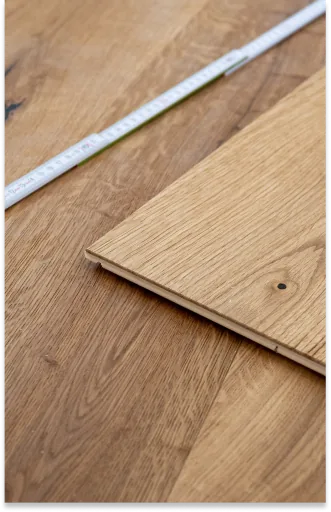 Holzdiele beim Verlegen mit Zollstock